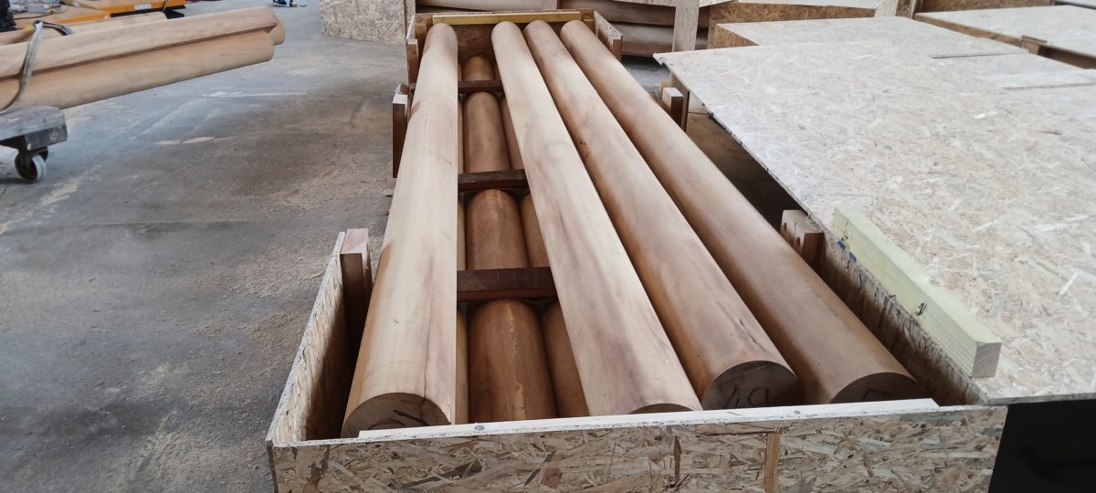 Bois ronds massifs soigneusement rangés et conditionnés dans une caisse en bois pour l’expédition.