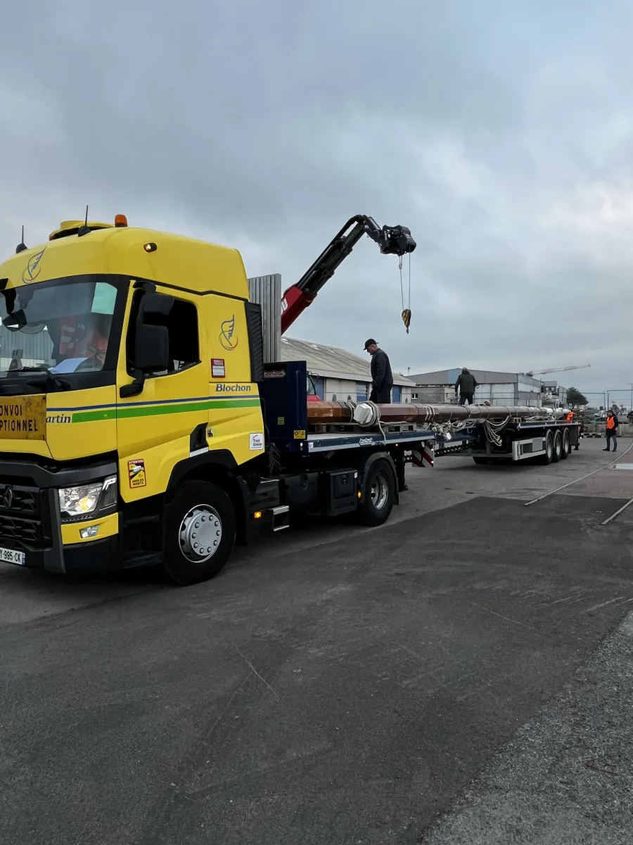 Convoi exceptionnel Blochon Martin chargeant un grand mât en bois lamellé collé WoodSpars sur semi-remorque plateau